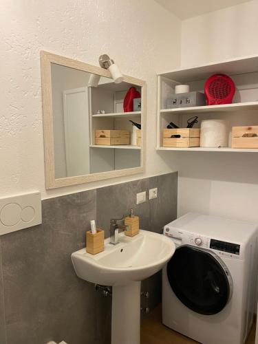 a bathroom with a sink and a washing machine at Appartamento Antey Saint André posizione centrale in Antey-Saint-André