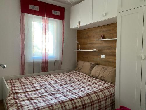Appartamento Antey Saint André posizione centrale في آنتي-سان-أندريه: غرفة نوم صغيرة بها سرير ونافذة