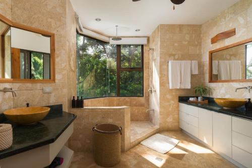 La salle de bains est pourvue de 2 lavabos et d'une baignoire. dans l'établissement Casa Anjali by Sandglass, à Quepos