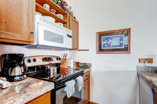 a kitchen with a stove and a microwave at Jackpine & Black Bear Condominiums by Keystone Resort in Keystone