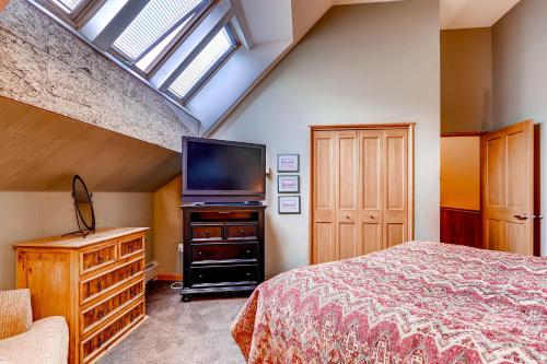 a bedroom with a bed and a flat screen tv at Jackpine & Black Bear Condominiums by Keystone Resort in Keystone