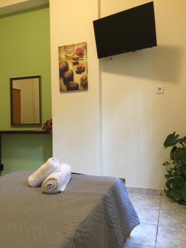 a bedroom with a bed and a flat screen tv at happyWish Syros in Ermoupoli