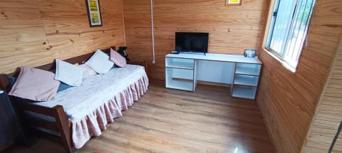 a room with a bed and a desk and a television at Casita con vista al mar in Salinas