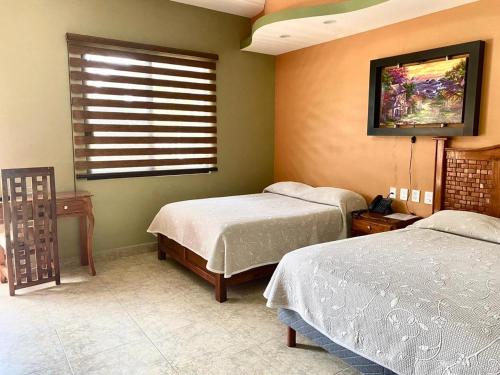 sypialnia z 2 łóżkami pojedynczymi i oknem w obiekcie HOTEL RESTAURANTE TEQUILA w mieście Jalpan