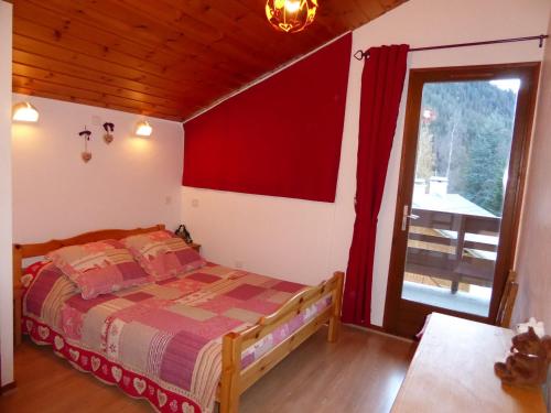 une chambre avec un lit et une porte coulissante en verre dans l'établissement Duplex ensoleillé à Champagny-en-Vanoise - Balcon et terrasse - Proche commerces et télécabine - FR-1-464-1, à Champagny-en-Vanoise