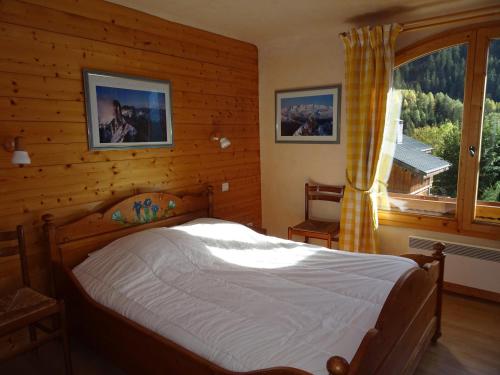 ein Schlafzimmer mit einem Bett und einem großen Fenster in der Unterkunft Appartement Champagny-en-Vanoise, 6 pièces, 12 personnes - FR-1-464-19 in Champagny-en-Vanoise