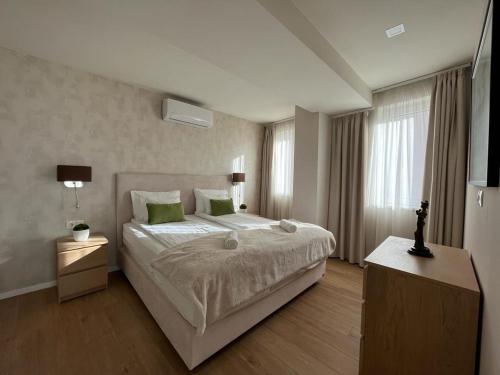 1 dormitorio con 1 cama grande con almohadas verdes en University city life bestern en Szeged