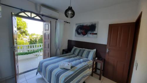 Pousada Casa Verde في غواراباري: غرفة نوم بسرير وشرفة