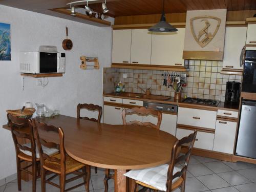 Il comprend une cuisine avec une table et des chaises en bois. dans l'établissement Chalet ensoleillé 3 pièces, 6 pers, jardinet, proche commerces et téléphérique, Pralognan-la-Vanoise. - FR-1-464-8, à Pralognan-la-Vanoise