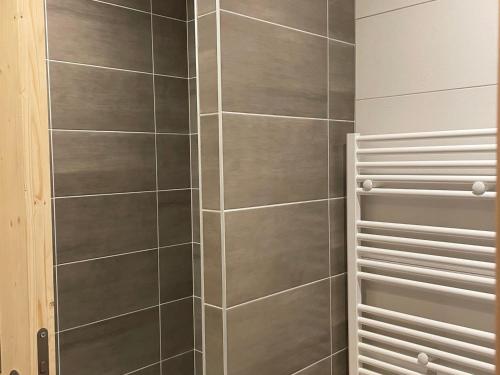 - une douche avec un mur carrelé gris dans l'établissement Appartement cosy 3 pièces - 6 personnes, balcon, centre, proche commerces et téléphérique - FR-1-464-12, à Pralognan-la-Vanoise