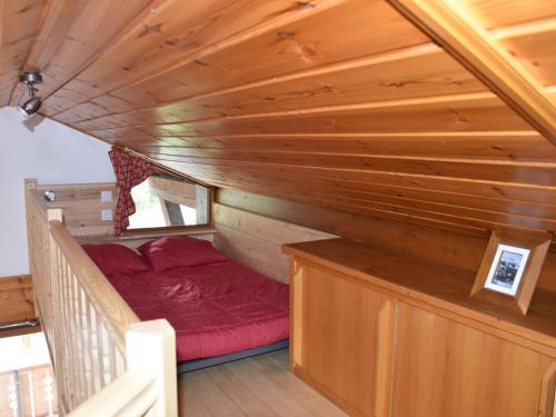 Cette petite chambre comprend un lit rouge dans une cabine. dans l'établissement Studio mezzanine, terrasse sud, proche commerces et télécabine à Champagny-en-Vanoise - FR-1-464-17, à Champagny-en-Vanoise