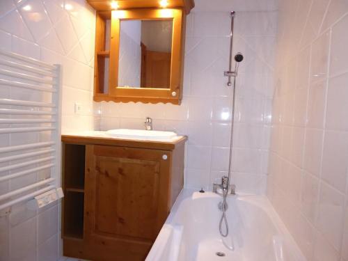 une salle de bain avec une baignoire, un lavabo et un miroir dans l'établissement Charmant T2 Montagne, Balcon, Proche Pistes - Pralognan-la-Vanoise - FR-1-464-4, à Pralognan-la-Vanoise