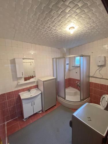 a bathroom with a shower and a sink and a tub at Triplex house near the airport in Arnavutköy