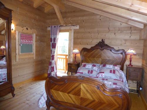 a bedroom with a bed in a log cabin at Chalet Haut de Gamme 5P avec Mezzanine, Parking, Proche Téléphérique et Pistes - Pralognan-la-Vanoise - FR-1-464-7 in Pralognan-la-Vanoise