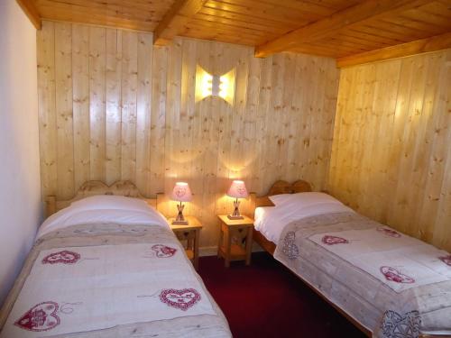 two beds in a wooden room with two lamps at Chalet Pralognan-la-Vanoise, 3 pièces, 6 personnes - FR-1-464-16 in Pralognan-la-Vanoise