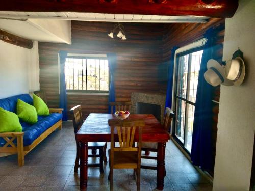 una sala da pranzo con tavolo e divano blu di Cabaña Mimi a Ciudad Lujan de Cuyo