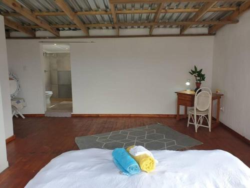 1 dormitorio con cama, mesa y escritorio en Best view of 1000 Hills with shared pool., en Bothaʼs Hill