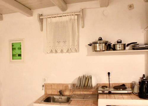 a kitchen with a sink and some pots and pans at Iliovasilema Studios Koufonisi in Koufonisia