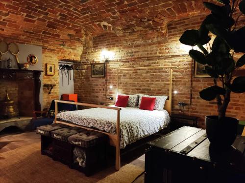 sypialnia z łóżkiem i ceglaną ścianą w obiekcie Corte dell'Uva w mieście Belveglio