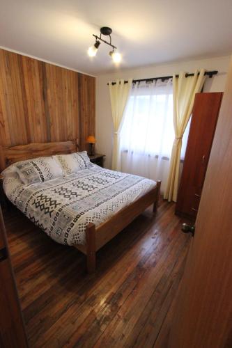 a bedroom with a bed with a wooden floor at Chile Wild - Las Vertientes in Malalcahuello