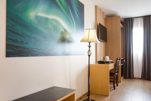 a hotel room with a desk and a painting on the wall at Hotel Jazz - By Keflavik Airport - Reykjavik - Iceland in Keflavík