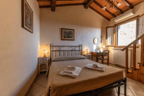 a bedroom with a bed with two towels on it at [Centro Storico - 5 Stelle] Chalet con Suite in San Gimignano