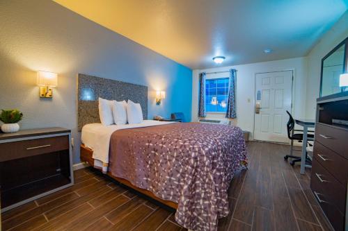 a hotel room with a bed and a desk at Turlock Inn in Turlock