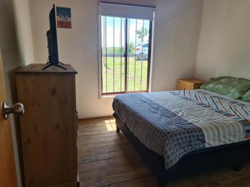 1 dormitorio con 1 cama, vestidor y ventana en Cabaña La Mañana Siguiente, en La Pedrera