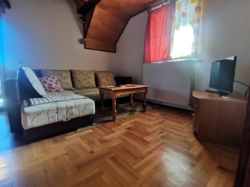 een woonkamer met een bank en een tafel bij Apartment Zlatibor Vesna in Zlatibor