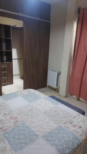 1 dormitorio con 1 cama y puerta de madera en Casalodge maipu en Maipú