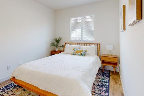 a white bedroom with a bed and a table at Tranquil Desert Sanctuary Permit# 50234 in Indio