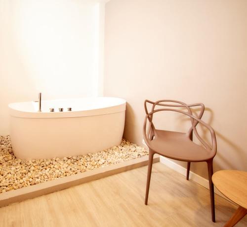 a chair and a bath tub in a bathroom at HOTEL FENCE in Medellín