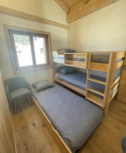 a bedroom with two bunk beds and a window at Chalet Clos du Nant Megève in Demi-Quartier
