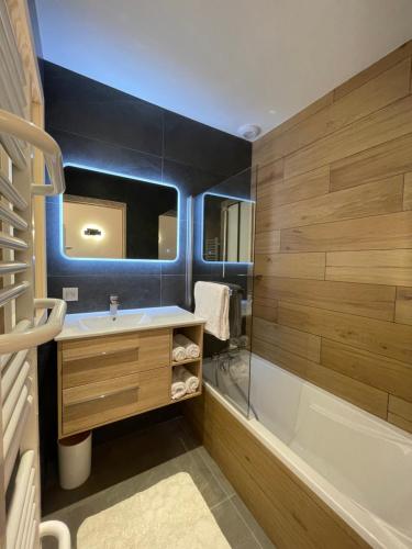 W łazience znajduje się wanna, umywalka i prysznic. w obiekcie Chalet Clos du Nant Megève w mieście Demi-Quartier