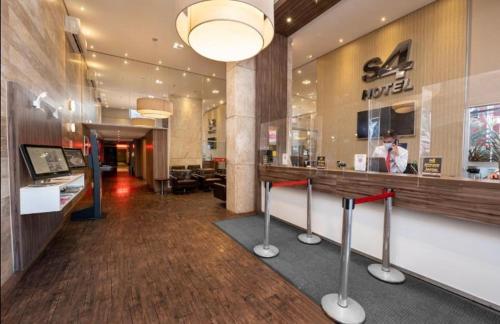a lobby of a restaurant with a counter and a person at FLAT 1417 in Águas Claras