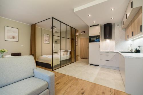 a living room with a couch and a bedroom at Holiday Baltic Sun in Sztutowo