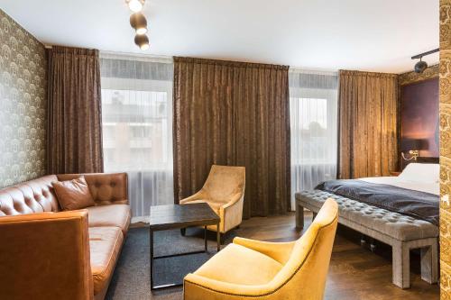 Habitación de hotel con cama y sofá en Vimmerby Stadshotell, WorldHotels Crafted, en Vimmerby