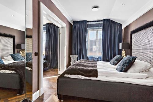 a bedroom with two beds and a large mirror at Vimmerby Stadshotell, WorldHotels Crafted in Vimmerby
