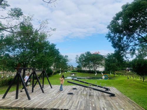 a group of people standing on a boardwalk in a park at 輕塵別院Serenegray B&B in Wujie
