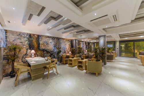 a restaurant with tables and chairs and a wall with paintings at Hotel Ocean Grand at Hulhumale in Hulhumale