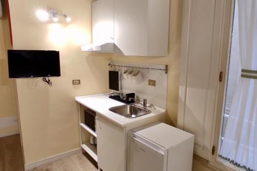 uma pequena cozinha com um lavatório e uma televisão em Appartamento Mughetto em Florença