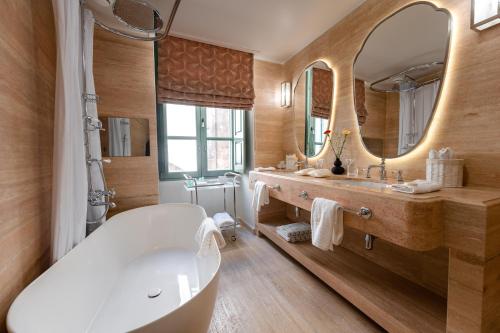 a bathroom with a tub and a large mirror at Palazzo Bifora in Mdina