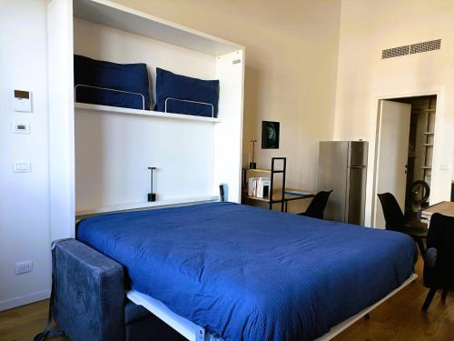 een slaapkamer met een groot bed met blauwe lakens bij Nuovo Loft con terrazzo M2 IEO Humanitas Bocconi Navigli in Milaan