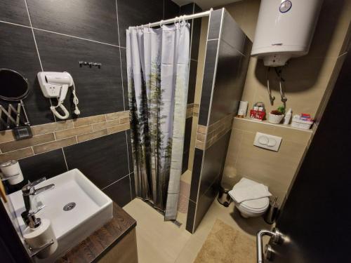 a small bathroom with a shower and a sink at Apartman Pleasure M4 Milmari Resort in Kopaonik