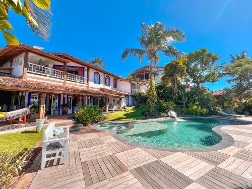 a villa with a swimming pool and a house at Vilatoro Guest House in Ilhabela