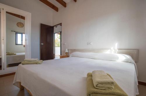 a bedroom with a white bed with towels on it at APARTAMENTOS CASA EUGENIO FORMENTERA in La Savina