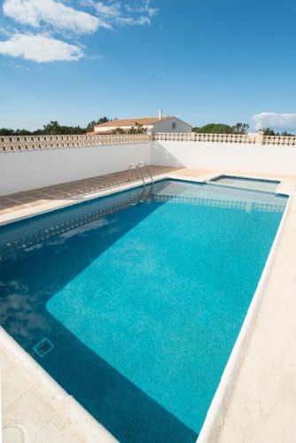 a swimming pool with blue water in a building at APARTAMENTOS CASA EUGENIO FORMENTERA in La Savina