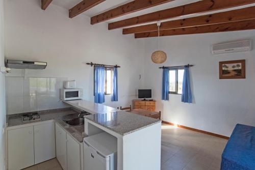 a kitchen with a counter top and a living room at APARTAMENTOS CASA EUGENIO FORMENTERA in La Savina