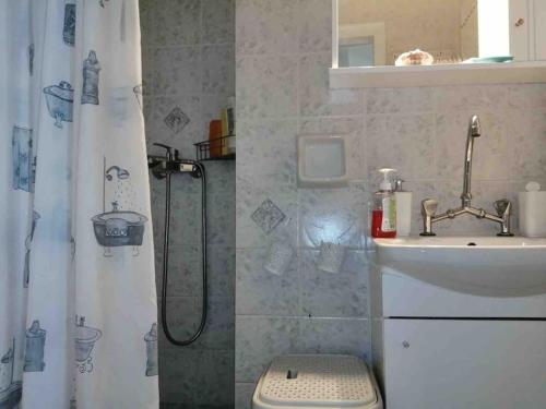 łazienka z zasłoną prysznicową i umywalką w obiekcie Σπίτι με απεριόριστη θέα w mieście Tríkeri