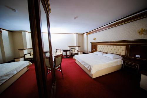 a hotel room with two beds and a desk at Cazare Plopii fara Sot in Iaşi